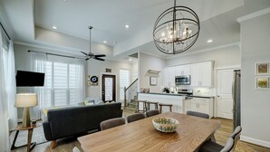 A modern kitchen with white cabinets, a stainless steel refrigerator, and a microwave.