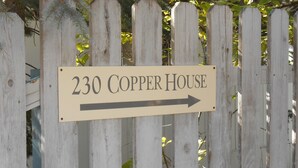 Ein Schild mit dem Schriftzug '230 Copper House' und einem nach rechts zeigenden Pfeil.