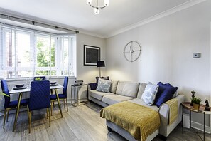 Apartamento básico, varias camas | Zona de estar | Una televisión