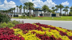 Ein Resort mit dem Schild "Windsor Island Resort“, umgeben von Palmen und einem angelegten Garten mit roten und gelben Pflanzen.