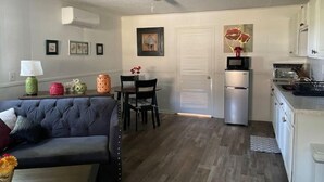 A compact living space with a sofa, dining table, and kitchenette. - Ell's Room (Harkers Island)