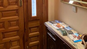 A wooden door with a window, a marble countertop with magazines, and a mirror on the wall. - Casa Rural Rincón de Ayllón (ayllon)