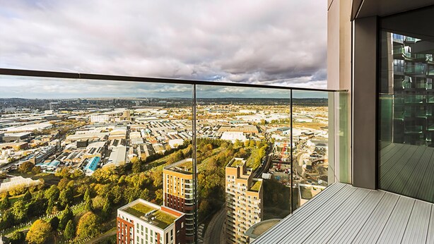 Un immeuble de grande hauteur offrant une vue sur le paysage urbain, avec divers bâtiments et un espace vert.