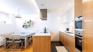 Une cuisine compacte dotée d’un îlot central, de meubles en bois et d’appareils électroménagers modernes.