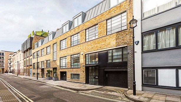 Une rangée d’immeubles modernes aux façades en briques et aux grandes fenêtres.