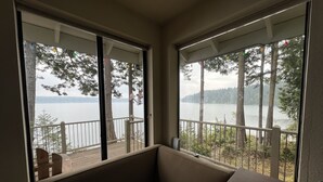 Ein Eckzimmer mit Seeblick und Bäumen.