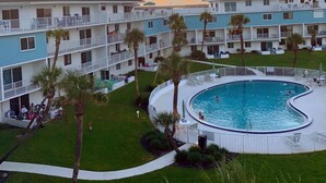 Ein Hotel mit Pool, Palmen und Blick auf den Sonnenuntergang.