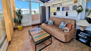 Un salon avec un canapé marron, une table basse et une bibliothèque remplie de livres.