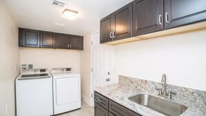 A kitchen with dark cabinets, a granite countertop, and a stainless steel sink. - Private Two Bedroom, Two TVs, One Bathroom Casita! (Las Vegas)
