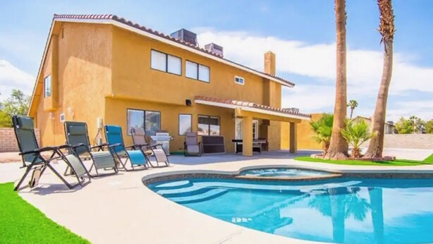 A two-story house with a swimming pool, outdoor seating, and palm trees. - Private Two Bedroom, Two TVs, One Bathroom Casita! (Las Vegas)