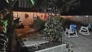 Eine Terrasse mit Holzlattenzaun, Pflanzkübeln und Sitzgelegenheiten.