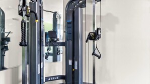 A gym with a weight machine labeled 'TRUE' and a mirror. - Woodspring Suites South Houston Hobby (Houston)