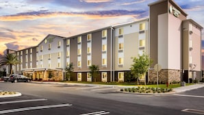 A multi-story hotel with a flat roof, large windows, and a stone facade.