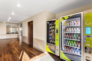 A hotel corridor with a vending machine stocked with snacks and drinks.