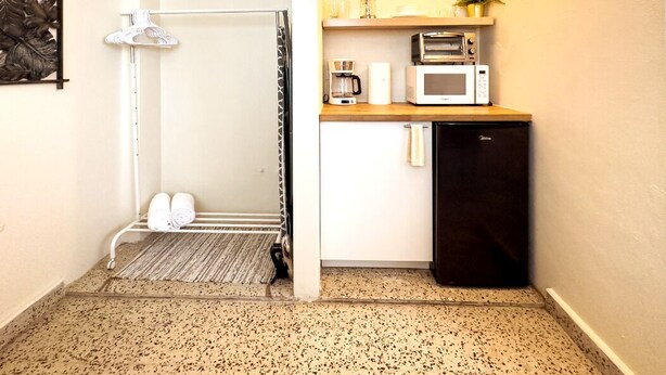 A compact kitchen with a microwave, toaster, and coffee maker. - Boho chic 2 bedroom in Miramar  1B (San Juan)