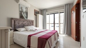 Une chambre à coucher avec un lit, une table de chevet, une fenêtre avec des rideaux et une porte.