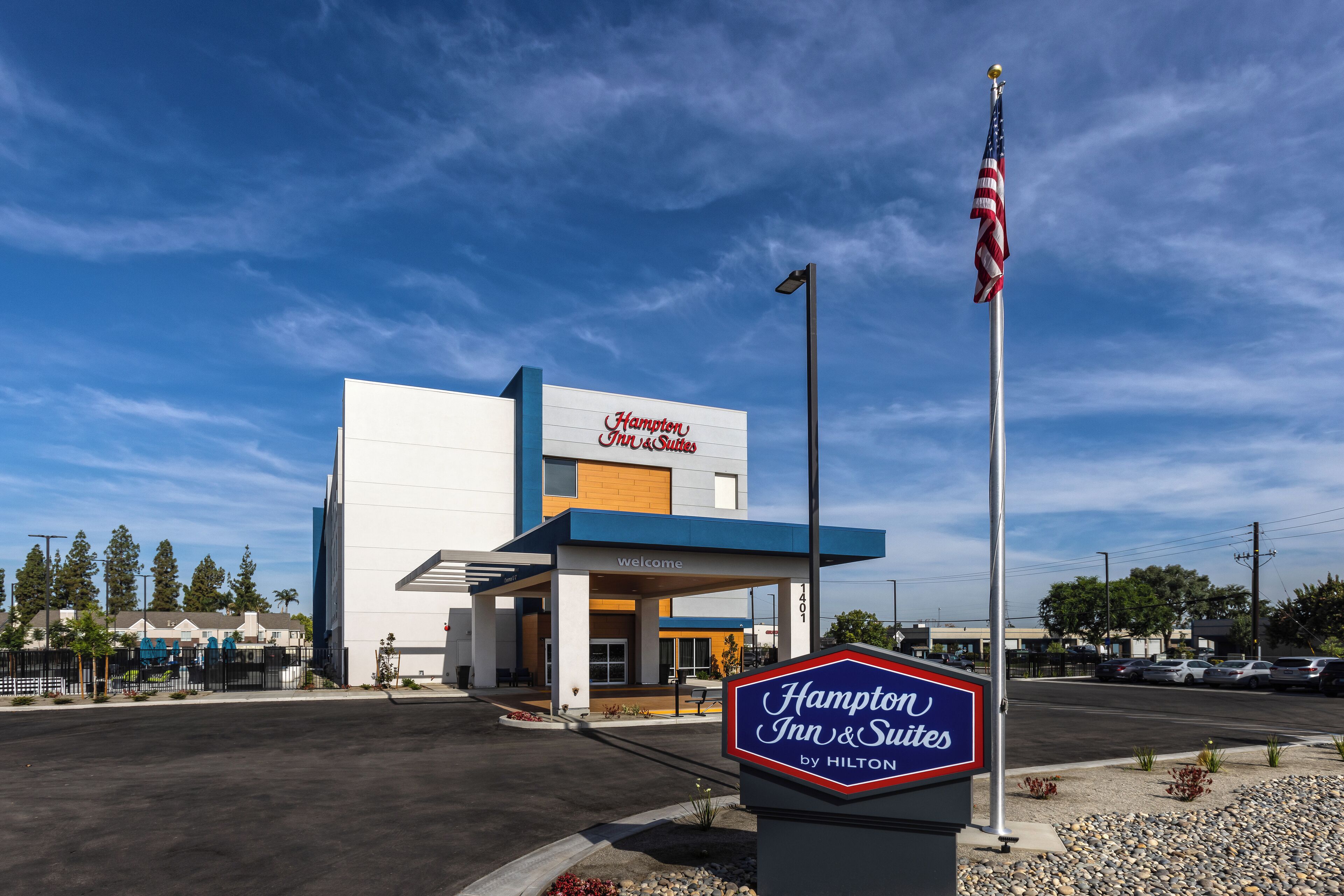 A Hampton Inn & Suites by Hilton building with a clear sky.