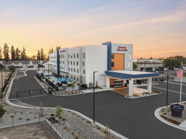 A Hampton Inn & Suites hotel with a parking lot, outdoor seating area, and a gas station. - Hampton Inn & Suites Bakersfield Central (Bakersfield)