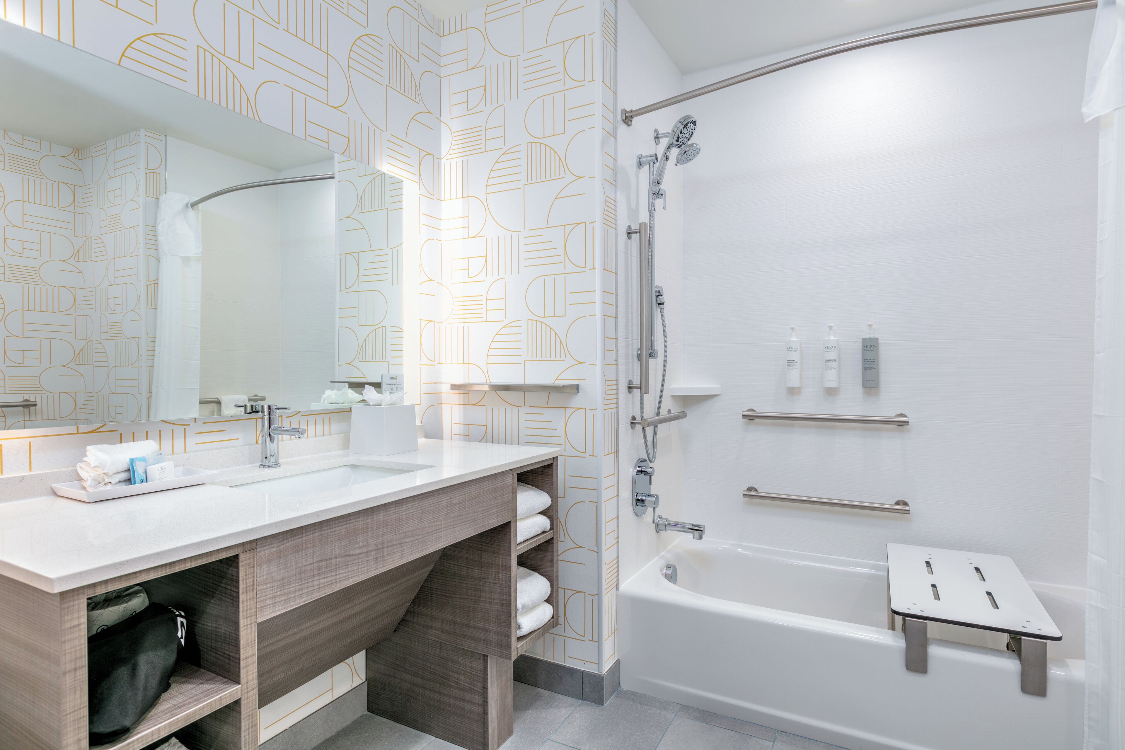 Ein modernes Badezimmer mit einem großen Spiegel, einem Holzbadezimmermöbel, einer Badewanne und einer Dusche.