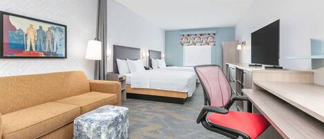 A hotel room with a sofa, a bed, a desk, a chair, a television, and a painting on the wall.