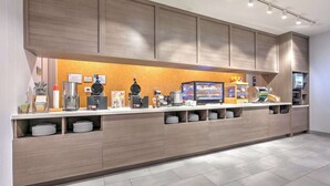 Una moderna zona de recepción de hotel con un mostrador largo, diversos servicios y una distribución limpia y ordenada.