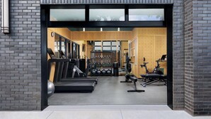 A modern gym with treadmills, weights, and exercise bikes.