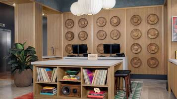 Una cocina moderna con detalles de madera, una isla central con estanterías y una pared decorada con cestas tejidas.