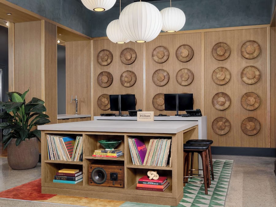 Una cocina moderna con detalles de madera, una isla central con estanterías y una pared decorada con cestas tejidas.