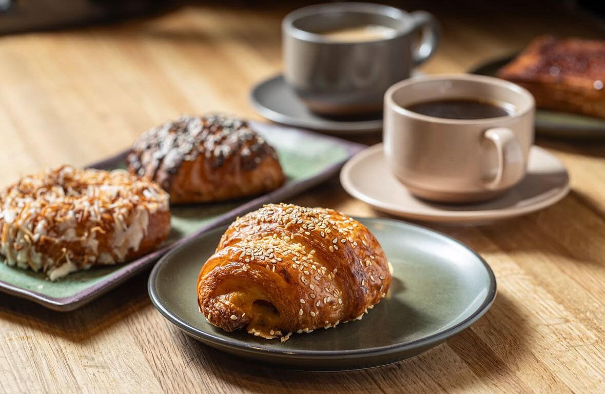 A table with pastries and cups of coffee.