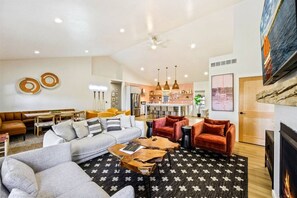 A modern living room with a sofa, armchairs, a coffee table, and a fireplace.