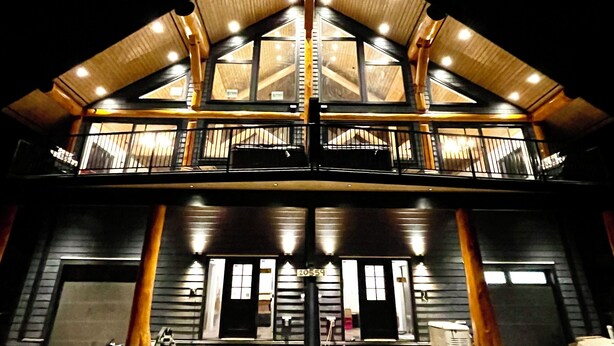 A two-story building with a prominent balcony and large windows. - Timberwolf A Cabin at Sasquatch Mountain  *HOT TUB* GAMES ROOM* (Agassiz)