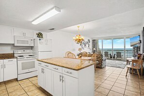 A modern kitchen with white cabinets, a granite countertop, and a central island.