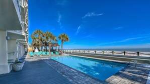 A poolside area with a clear view of the ocean, a wooden deck, and lounge chairs. - Oceanfront 2bed/2bath-Water's Edge Resort-711 Indoor/Outdoor Pool & Hot Tub (Garden City Beach)