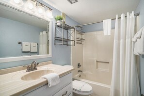 A bathroom with a sink, mirror, and shower. - Oceanfront 1bed/2bath-Water's Edge Resort-403 Indoor/Outdoor Pool & Hot Tub (Garden City Beach)