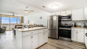 Una cucina moderna con mobili bianchi, elettrodomestici in acciaio inossidabile e un'isola grande.