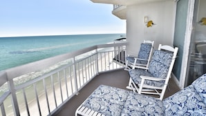 A balcony with white railings, a white chair with a blue patterned cushion, and a white sofa with a blue patterned cushion. - Oceanfront 1bed/2bath-Water's Edge Resort-1405 Indoor/Outdoor Pool & Hot Tub (Garden City Beach)