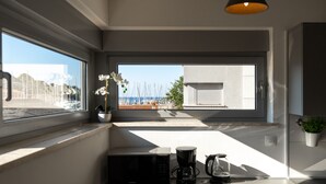 A modern kitchen with a large window, a potted orchid, a coffee maker, and a microwave. - Modern apartment directly at the marina Vrsar and 300m from the beach (Vrsar)