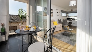 A modern living space with a balcony, a dining area with a table and chairs, a sofa, and a kitchen area. - Modern apartment directly at the marina Vrsar and 300m from the beach (Vrsar)