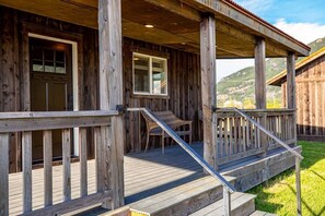 Eine Holzhütte mit Veranda, Tür und Fenster.