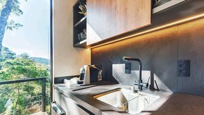 A modern kitchen with a large window, a built-in oven, and a sink. - Rancho Carolina (Rancho Queimado)
