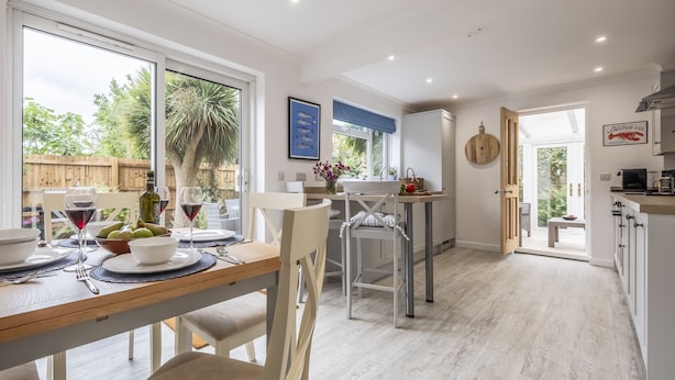 A modern kitchen with a dining area, large windows, and a view of the outdoors. - Miramare Cottage,  Holme-next-the-Sea, Norfolk (Holme-next-the-Sea)