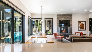 Amplia sala de estar con chimenea, vista a la piscina y diseño moderno.