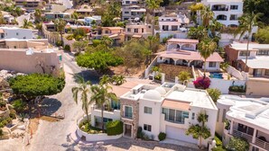 A residential area with modern houses, a swimming pool, and palm trees. - Villa Cola de Ballena Luxury Villa with ARCADE Room, El Pedregal. Security 24/7 (Cabo San Lucas)