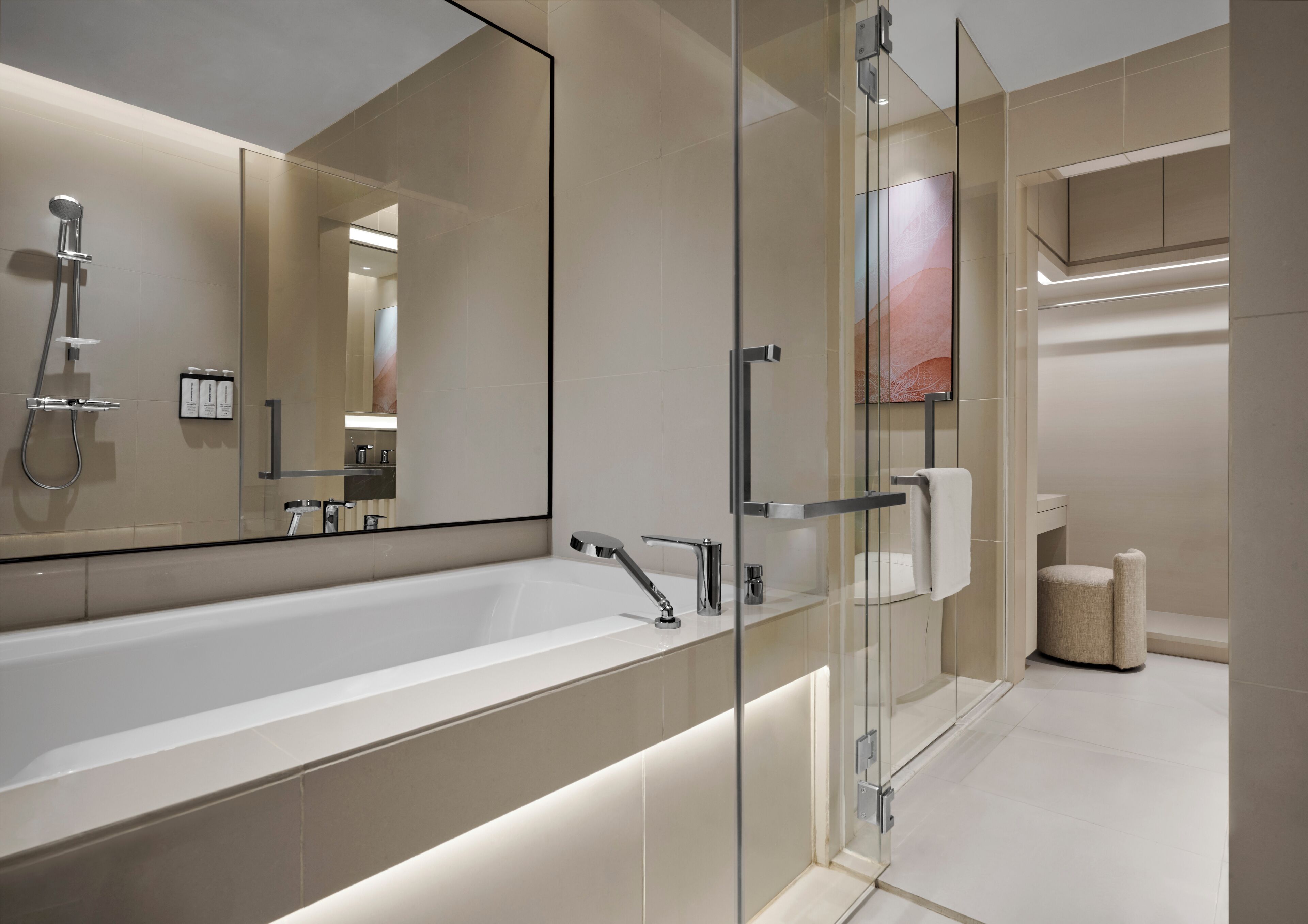 A modern bathroom with a large glass-enclosed shower, a spacious white bathtub, and a minimalist design.