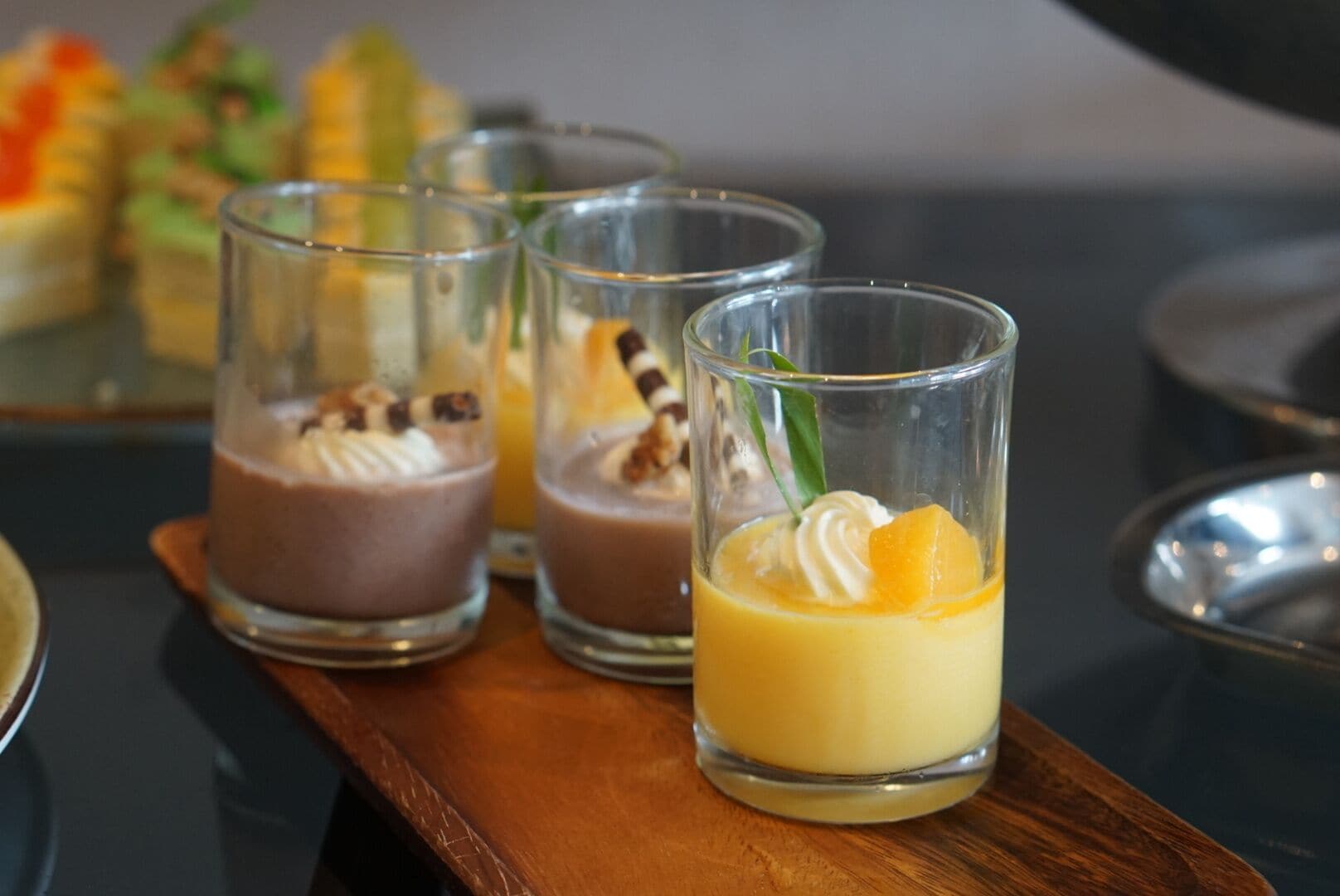 Tres vasos de postre sobre una bandeja de madera.