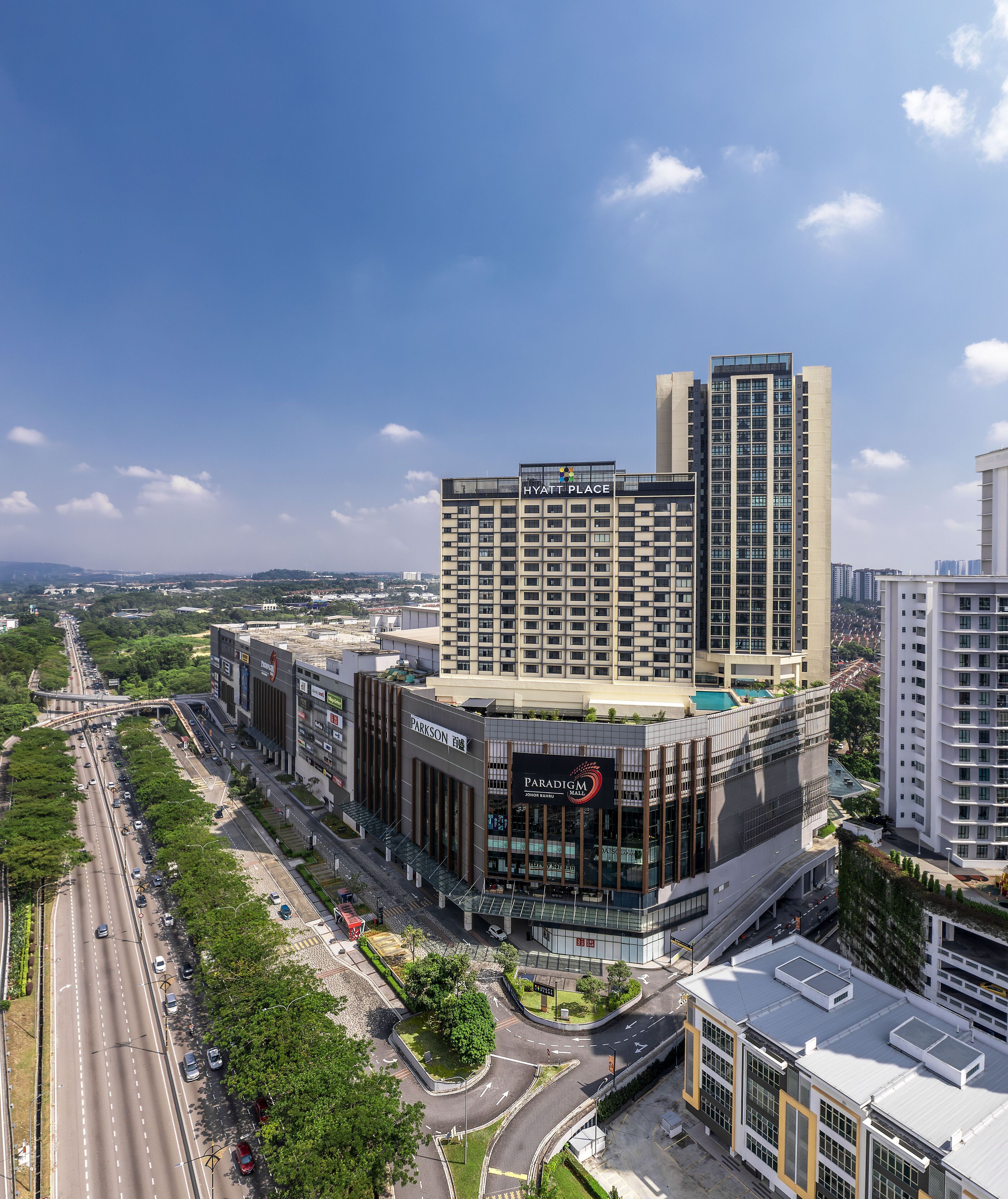 A modern hotel with a prominent 'Hyatt Place' sign, a rooftop pool, and a 'Paradigm Mall' adjacent to it.