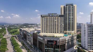 A modern hotel with a prominent 'Hyatt Place' sign, a rooftop pool, and a 'Paradigm Mall' adjacent to it.