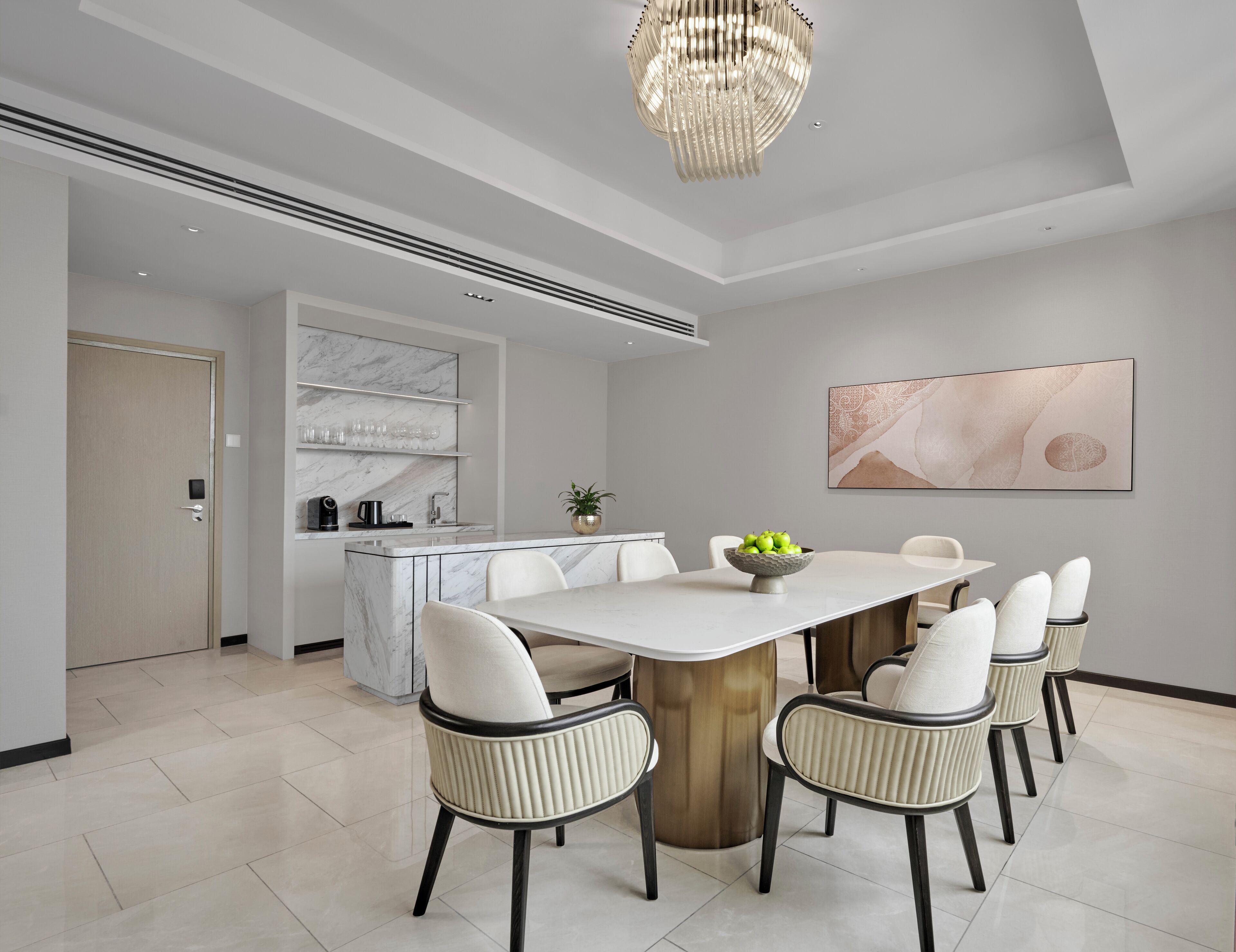 A modern kitchen with a marble backsplash, a central island, and a dining area with a large table and chairs.