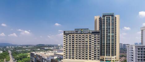 A modern hotel with a prominent 'Hyatt Place' sign, a 'Parkson' building adjacent, and a 'Paradigm Mall' nearby.
