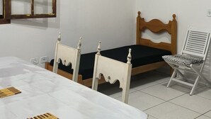 Une pièce comprenant une table à manger, des chaises, un lit et deux tableaux accrochés au mur.